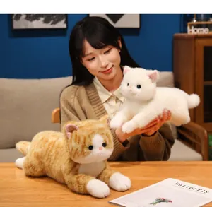 Modella asiatica con un realistico peluche di gattino bianco e gatto soriano arancio