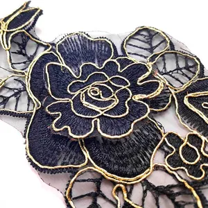 Close-up of black and gold embroidered rose flower applique on fine organza mesh