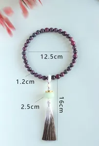Detailed view of traditional Chinese Buddhist bead bracelet with tassel and size markings