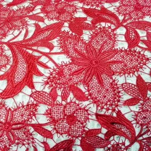 Gros plan sur un tissu en dentelle guipure rouge avec broderie florale ajourée