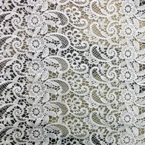 Close-up detail of white water-soluble lace fabric with hollow embroidery pattern