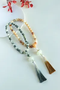 Detailed view of Bodhi lotus bead bracelets with elegant long tassels and marbled textures.