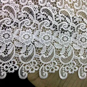 Macro detail of white water-soluble lace fabric with intricate floral embroidery