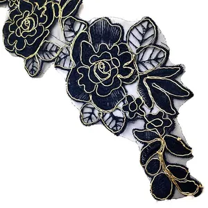 Macro view of black rose embroidery with gold thread on mesh fabric