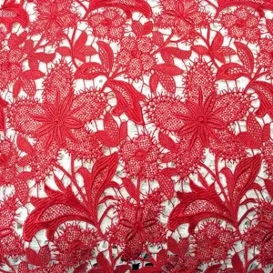 Vue détaillée de dentelle rouge hydrosoluble avec des motifs floraux brodés complexes