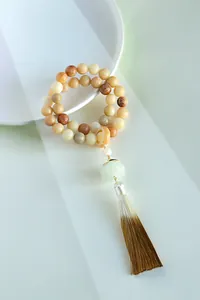 Detail of double-layer Bodhi seed bracelet with lotus bead and brown tassel
