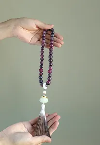 Detail of Chinese style Buddhist prayer beads with lotus charm and long tassel ornament