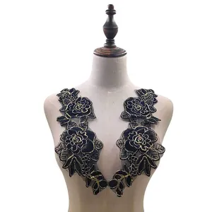 Macro view of black rose floral embroidery patches with gold outlines on a mannequin