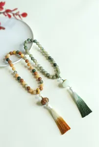 Detailed view showing two lotus bodhi bead bracelets featuring elegant gradient silk tassels