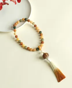 Macro view of carved lotus Bodhi seed beads with a silk gradient tassel detail