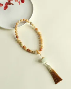 Close-up detail of traditional Bodhi seed prayer beads with lotus charm and silk tassel