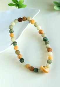 Close-up detail of multi-colored lotus flower carved beads on a spiritual prayer bracelet