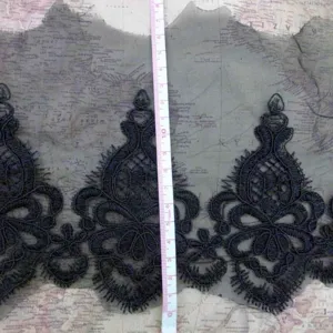 Close-up detail of black water-soluble lace embroidery trim showing intricate patterns