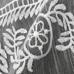 Gros plan sur tissu dentelle brodé en soie de lait blanc avec motif floral et base résille