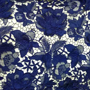 Detailed view of heavy dark blue 3D floral embroidery on water-soluble lace fabric