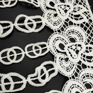 Macro detail of white water-soluble milk silk lace trim with 3D hollow floral pattern