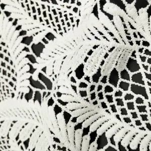 Close-up detail of white water-soluble milk silk lace fabric with floral embroidery pattern