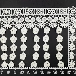 Detailed view of white milk silk embroidered water-soluble lace trim with flower tassels