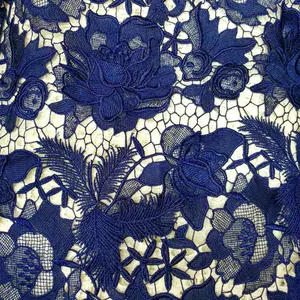 Close-up detail of navy blue water-soluble lace with 3D floral and feather embroidery