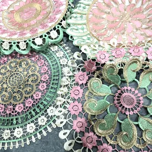 Detailed macro view of colorful embroidered lace round coasters and placemats.