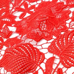 Makrodetail von rotem wasserlöslichem Spitzenstoff mit Blattstickerei