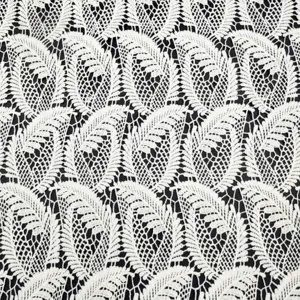 Detailed macro shot of white milk silk water-soluble lace fabric with hollow embroidery