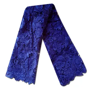 Detail view of royal blue water-soluble lace fabric with intricate floral embroidery patterns.