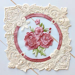Macro detail of elegant cream lace placemat featuring exquisite pink floral embroidery