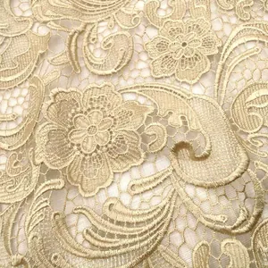 Nahaufnahme von goldenem Paisley-Spitzenstoff mit feiner 3D-Blumenstickerei.