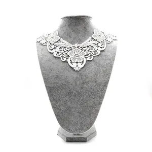 Close-up of white water-soluble lace collar with detailed floral embroidery pattern