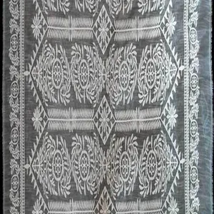 Détail de broderie en soie de lait fleurie blanche sur tissu de dentelle soluble gris