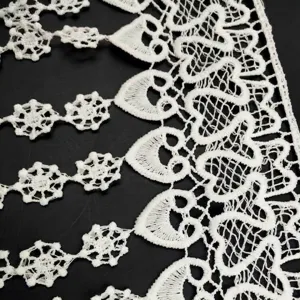 Detailed close-up of white water-soluble milk silk lace trim with heart patterns