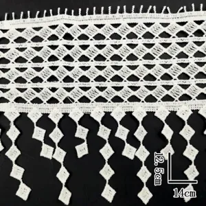 Nahaufnahme von weißer wasserlöslicher Spitze mit rautenförmigen geometrischen Quasten