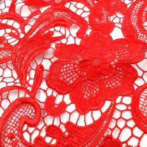 Detailaufnahme von rotem wasserlöslichem Spitzenstoff mit Paisleymuster und Stickerei