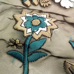Detailed macro shot showing heavy colorful floral embroidery on organza mesh fabric texture