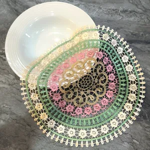 Macro detail showing colorful floral embroidery on openwork lace table mat for home decor