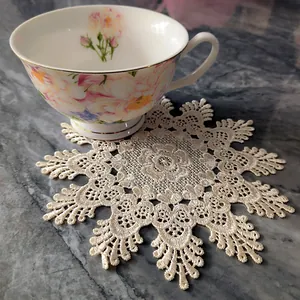Detail view of an elegant retro beige lace coaster with intricate floral embroidery.