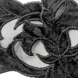 Close-up detail of black water-soluble lace embroidery with intricate floral mesh