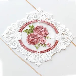 Detailed close-up view of a floral embroidered lace patch coaster with pink flowers pattern