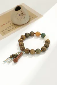 Détail d'un bracelet bouddhiste en bois de santal vert avec des accents de lotus sculptés