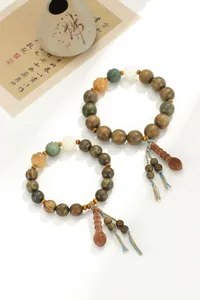 Vue détaillée de perles de prière en santal vert avec accents colorés