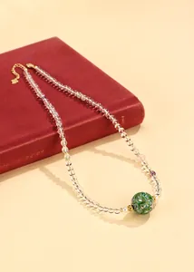 Elegante Halskette aus weißen Kristallperlen mit grüner Lackperle und kleiner Perle