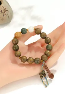 Vue détaillée d'un bracelet bouddhiste en bois de santal vert avec des perles de lotus ethniques