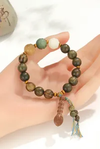 Vue détaillée d'un bracelet en bois de santal vert avec des perles de lotus et glands