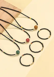 Detailed view of black onyx necklaces and bracelets featuring vibrant cinnabar lacquer beads.