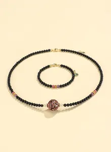 Black agate beaded necklace and bracelet set with ornate central lacquer bead