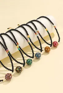 Detail view of handcrafted black agate bead necklaces with ornate lacquer charms.