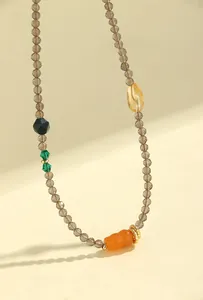 Detalle de cuentas de cuarzo ahumado facetado de 3 mm con colgante de jade naranja en forma
