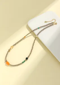 Primer plano de un collar de cuarzo ahumado de 3mm con un colgante de jade tallado
