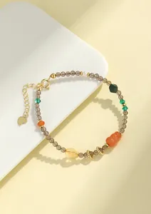 Primer plano de pulsera de cuarzo ahumado de 3mm con dije de calabaza y detalles dorados